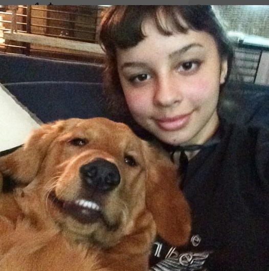 Picture of Kaila Chambers posing for a photo shoot with her dog wearing black color dress